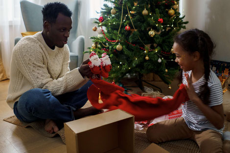 FATHER AND DAUGHTER PLAYING NEAR CHRISTMAS TREE