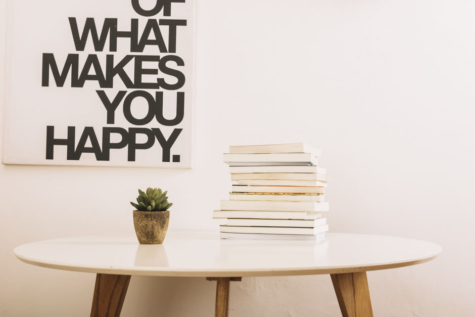 Table with a plant and books near wall indicating storytelling